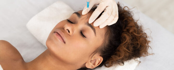 Botox being carefully injected into the forehead to smooth expression lines and create a subtle brow lift with natural-looking results.